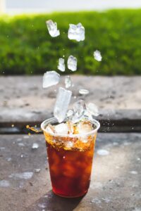 Dropping ice cubes into a cup of iced tea